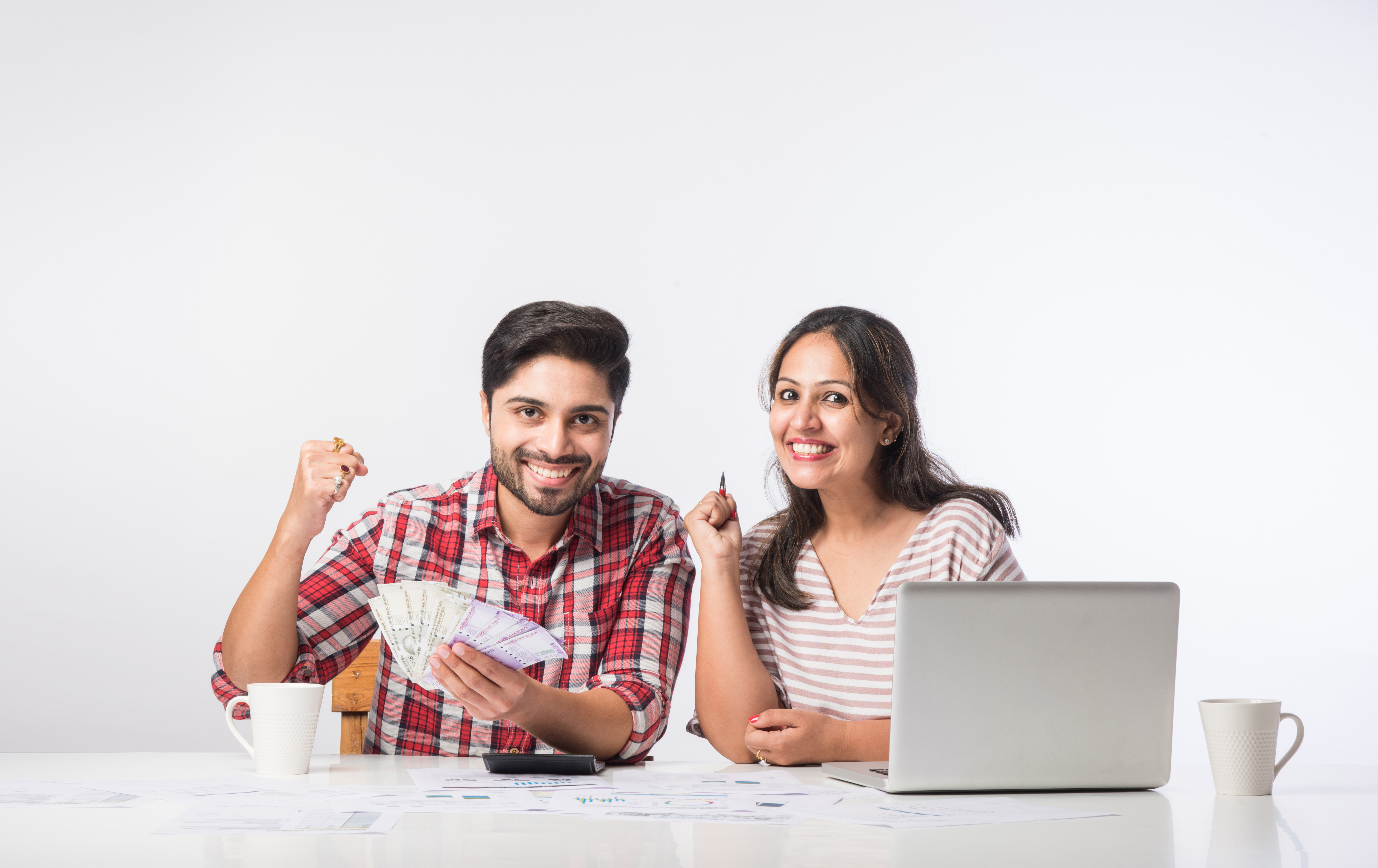 indian asian young couple accounting, calculating bills, planning budget for home loan using laptop